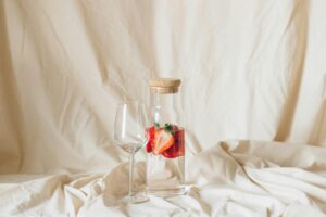 water with strawberry and wine glass